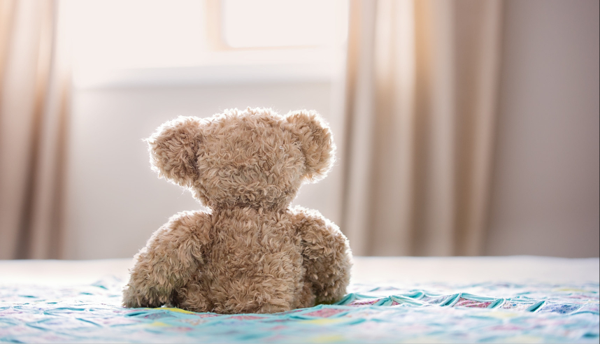 Teddy bear sitting on a bed