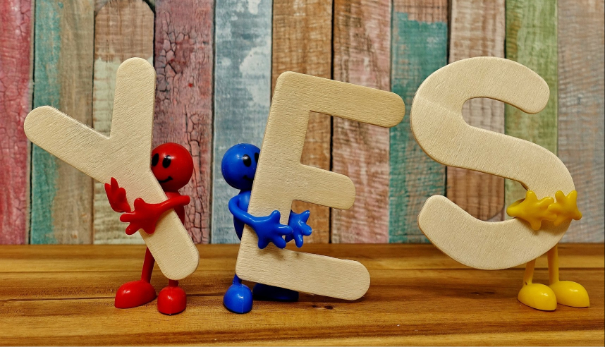 Different colour characters holding the word "YES"