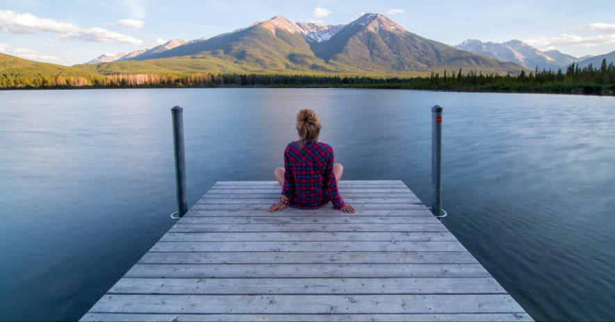 Person relaxing at the end of a pier