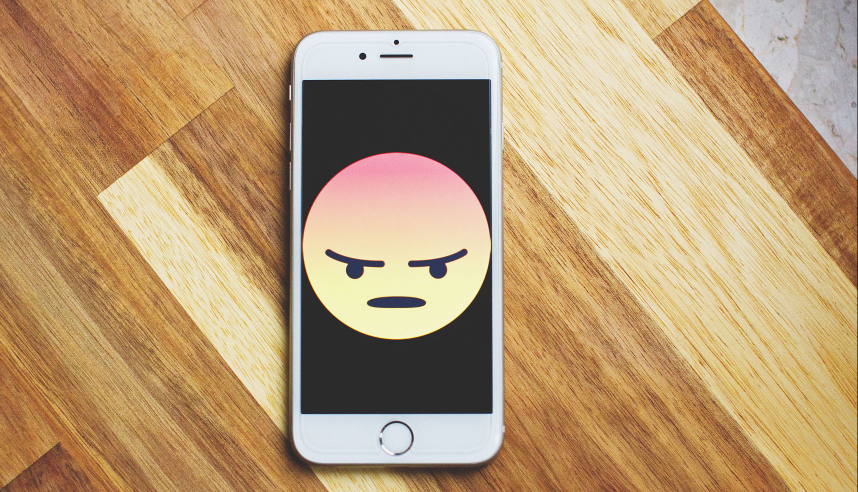 Smartphone with angry emoji on the screen